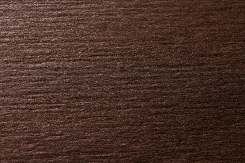 Close-up of dark chocolate brown textured paper surface