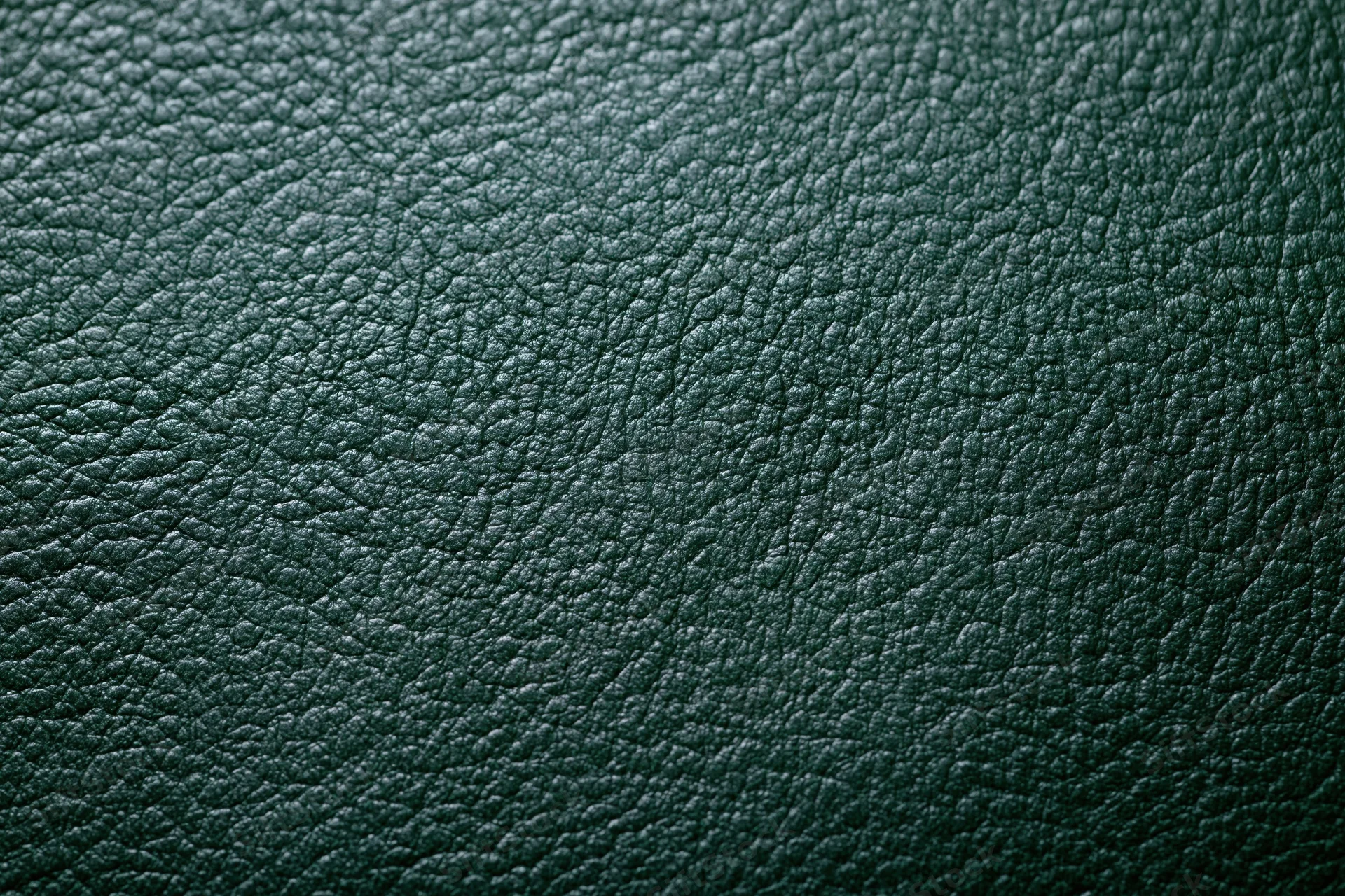 Close-up of dark forest green leather surface with pebbled texture