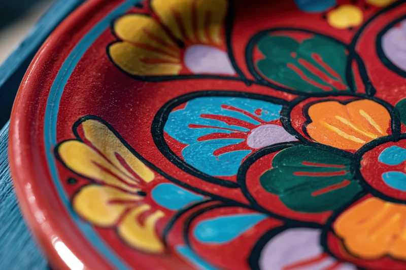 Close-up of a hand-painted mexican talavera ceramic plate with floral design in red and bright colors