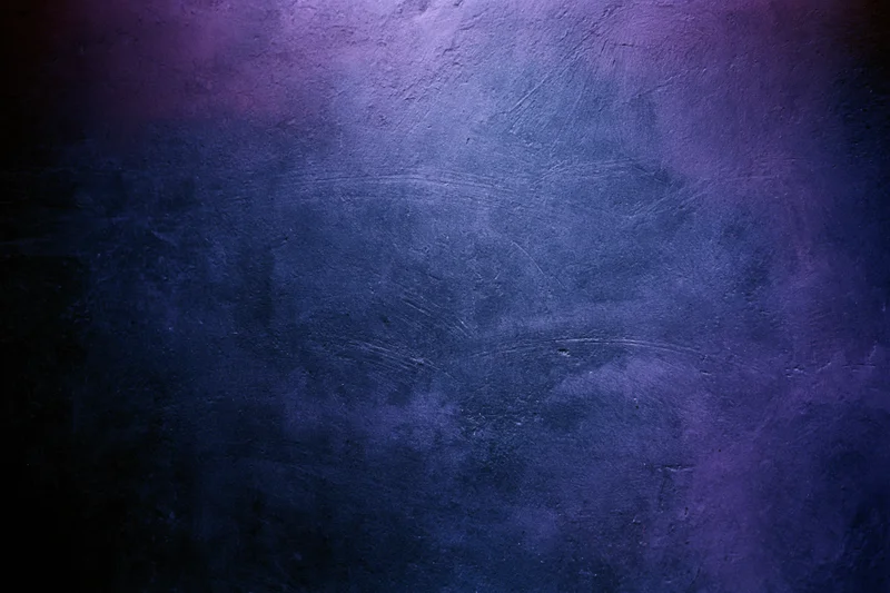 Close-up of a worn concrete wall surface with blue and purple gradient lighting