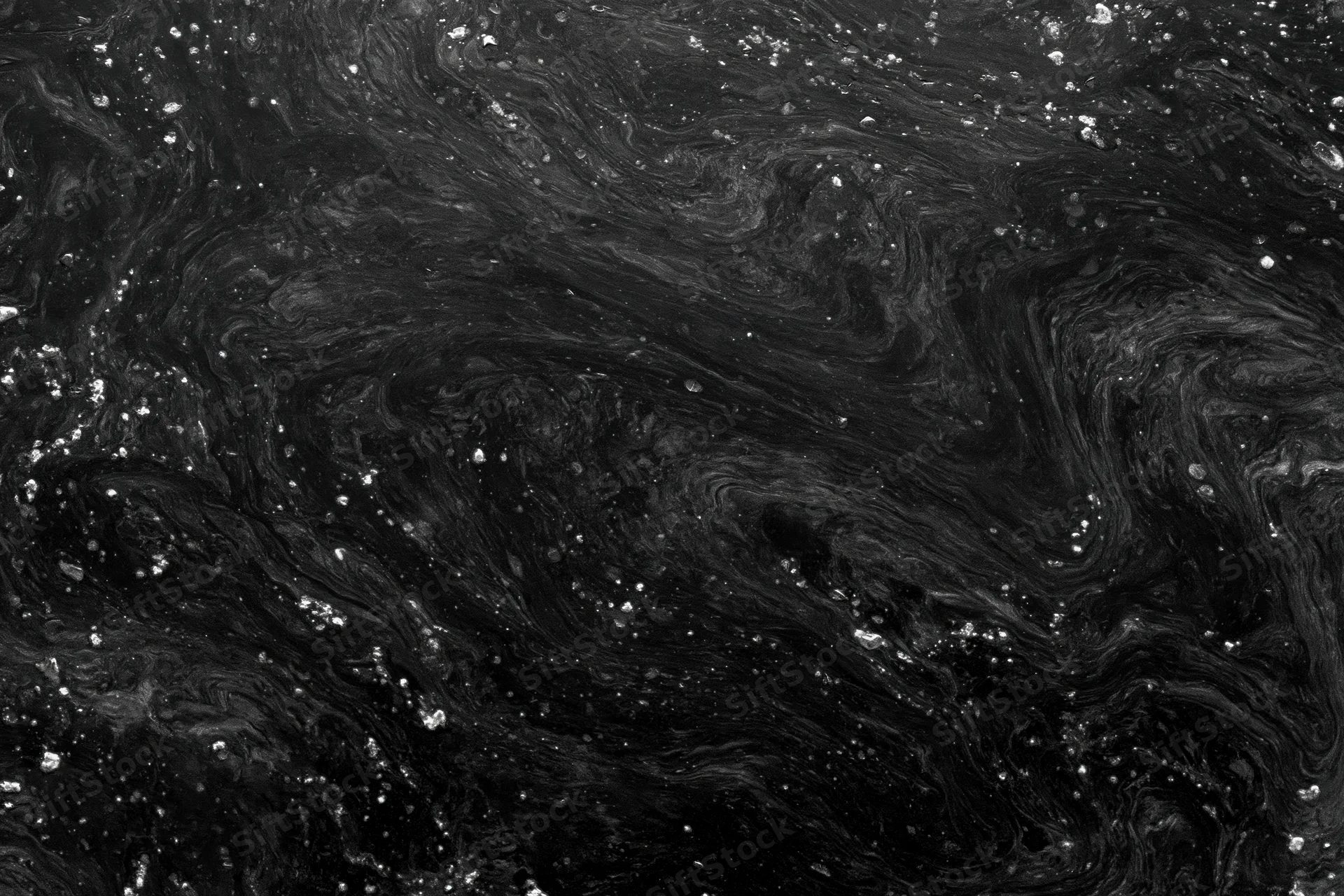 Swirling dark oily water surface with reflective sheen and scattered droplets