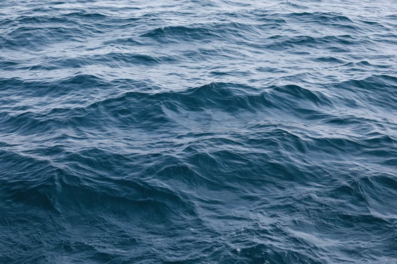 Close-up overhead view of open ocean surface with low rolling waves