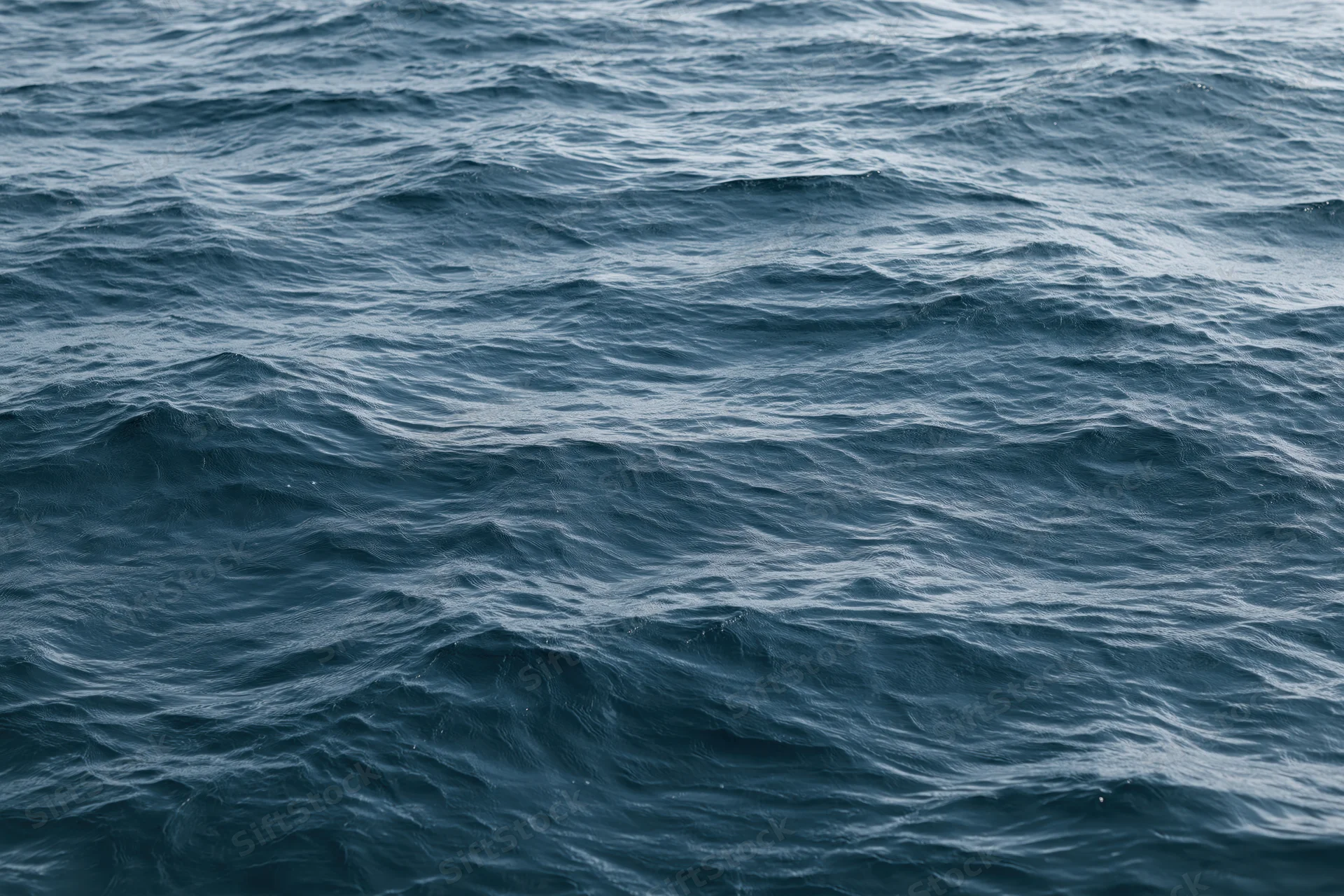 Close-up overhead view of open ocean surface with low rolling waves