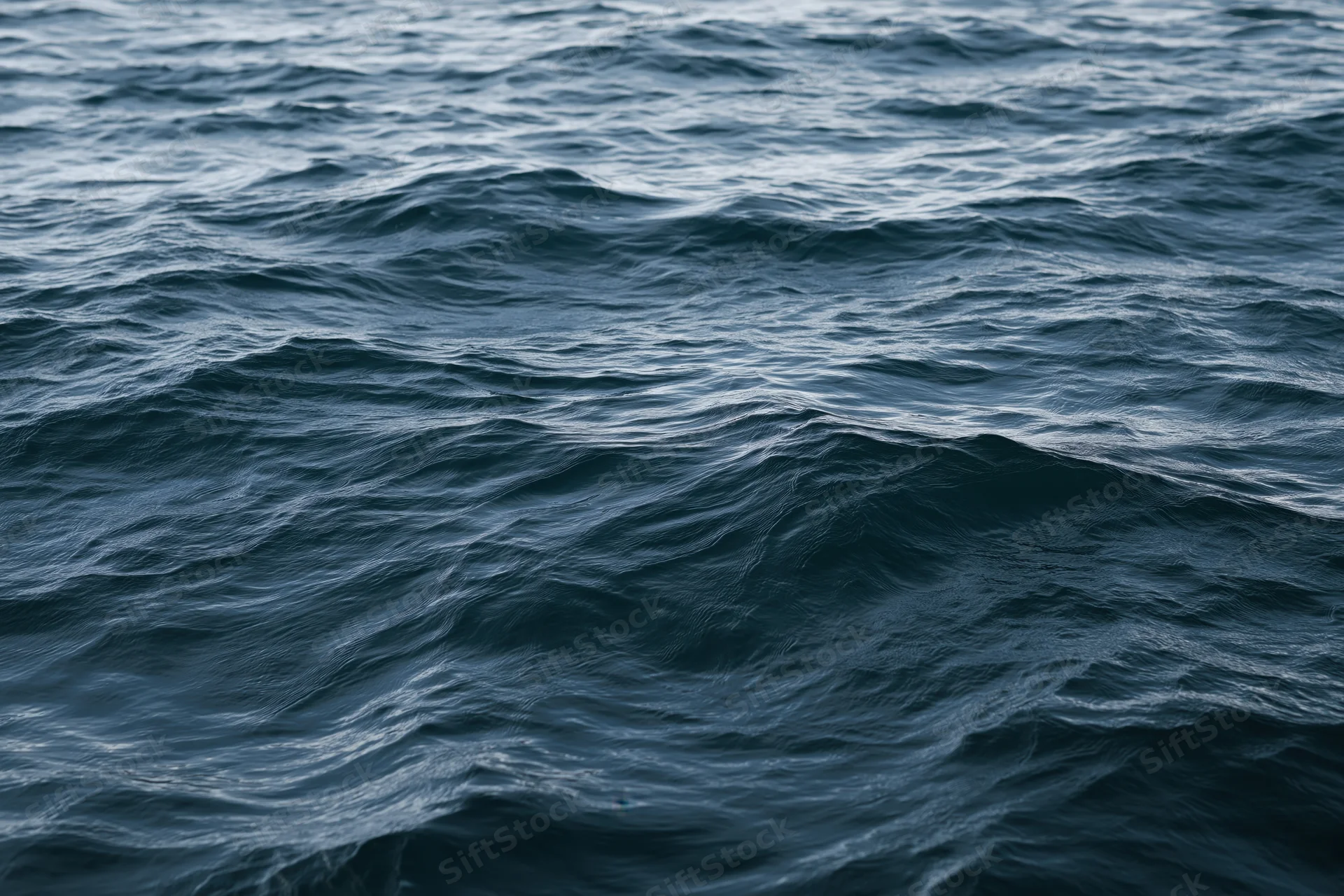 Close-up view of dark blue ocean waves rolling across the open sea surface