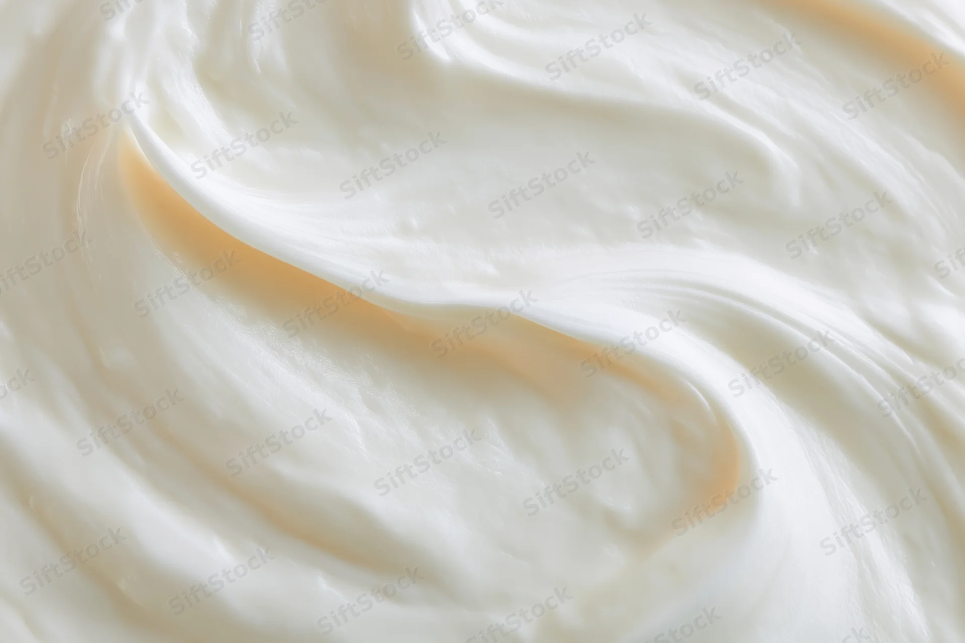 Close-up overhead view of thick creamy white yogurt swirls filling the frame