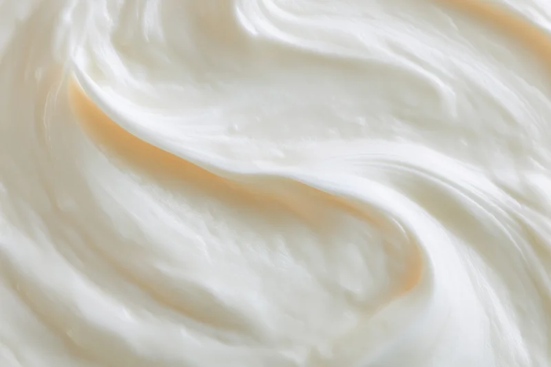 Close-up overhead view of thick creamy white yogurt swirls filling the frame
