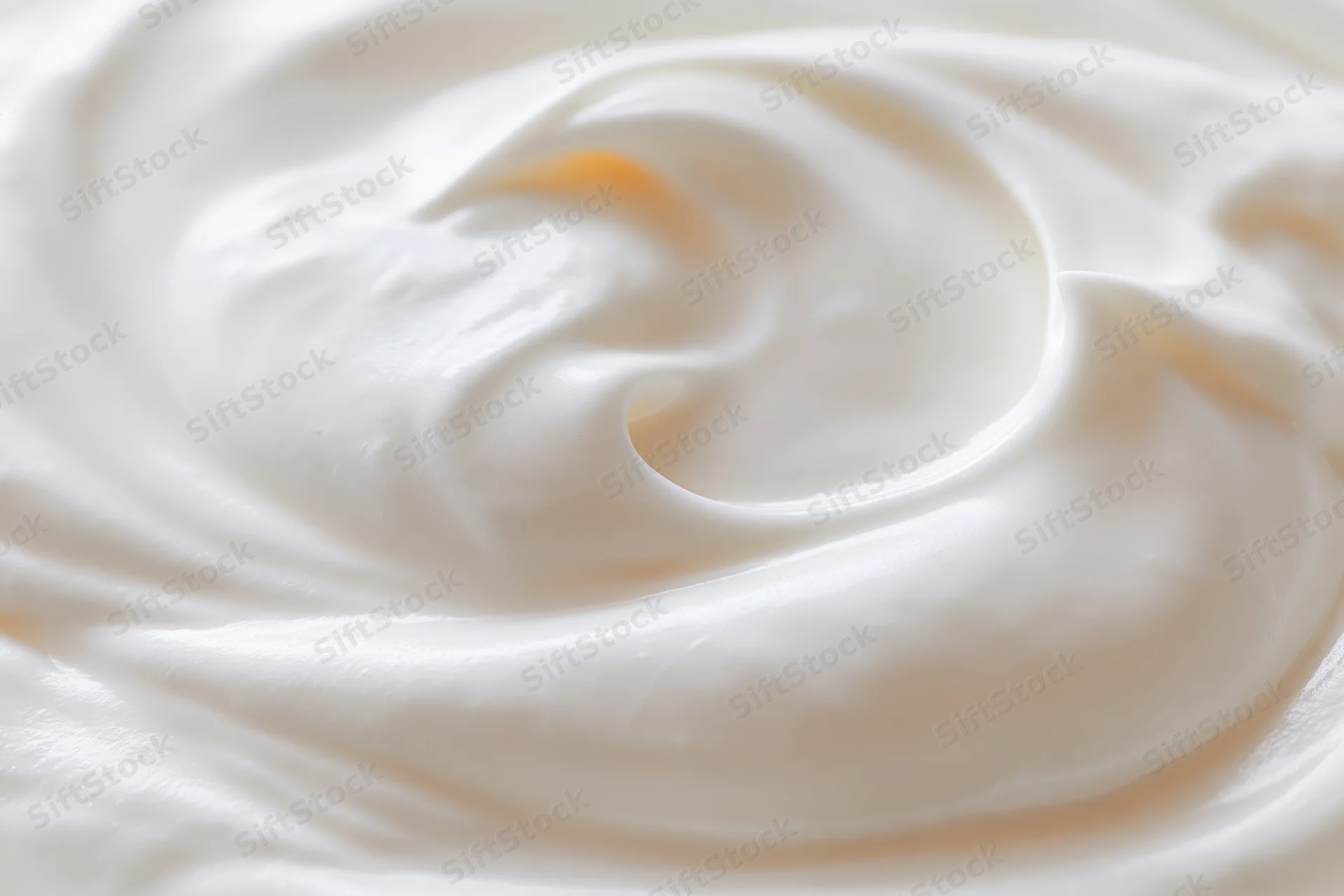 Close-up overhead view of thick creamy white yogurt swirl with smooth texture
