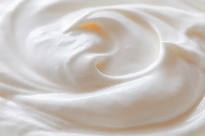 Close-up overhead view of thick creamy white yogurt swirl with smooth texture
