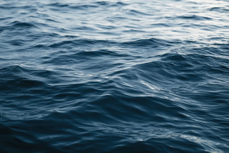 Close-up of dark ocean water surface with slow rolling ripples