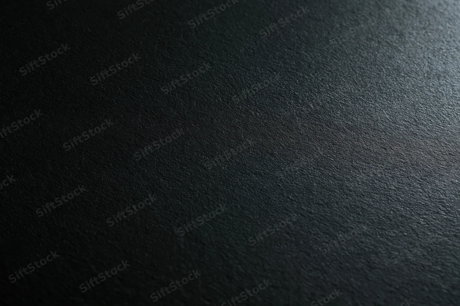 Dark charcoal matte surface filling the frame as a textured background