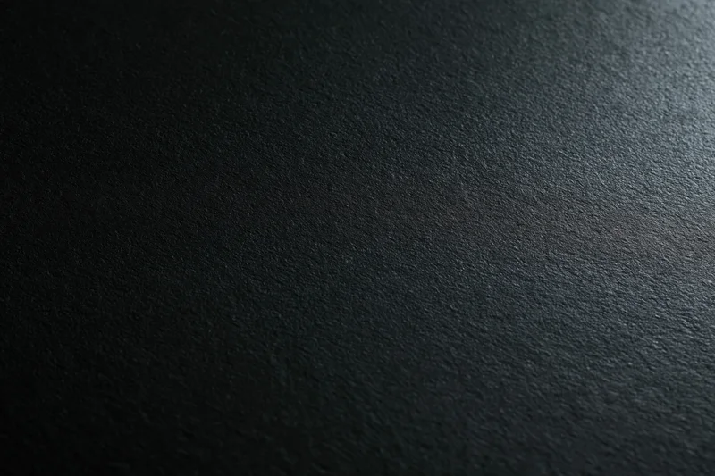 Dark charcoal matte surface filling the frame as a textured background
