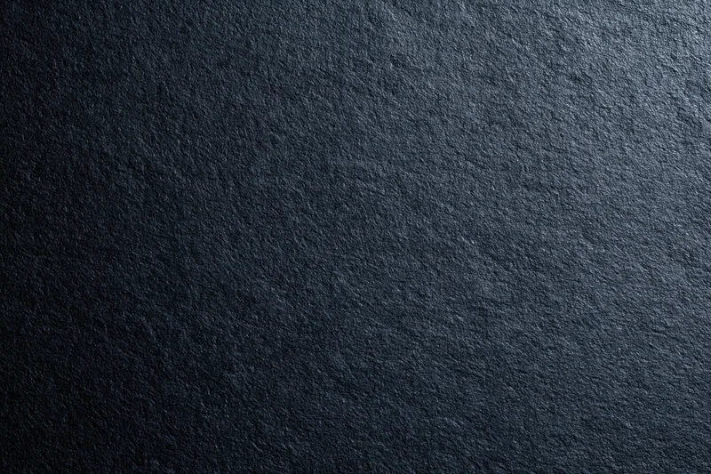 Dark charcoal matte surface filling the entire frame texture