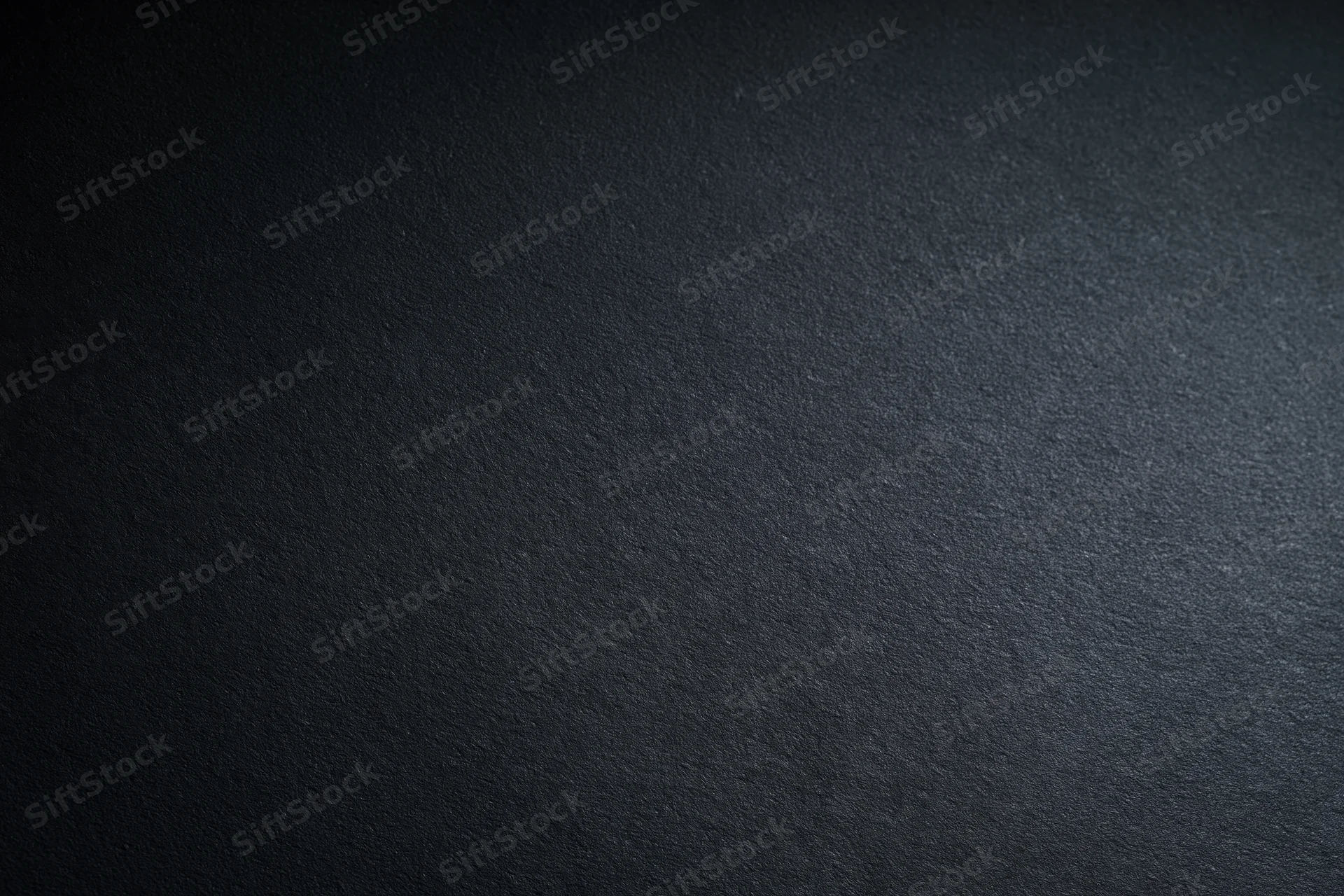 Dark charcoal matte surface filling the frame with subtle texture and even lighting