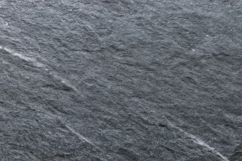 Dark grey slate stone surface with natural texture and veins filling the frame