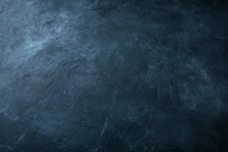 Dark mottled slate surface texture filling the frame