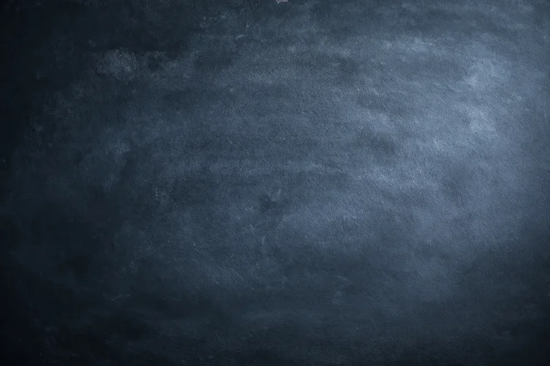 Dark mottled chalkboard surface with aged texture filling the frame