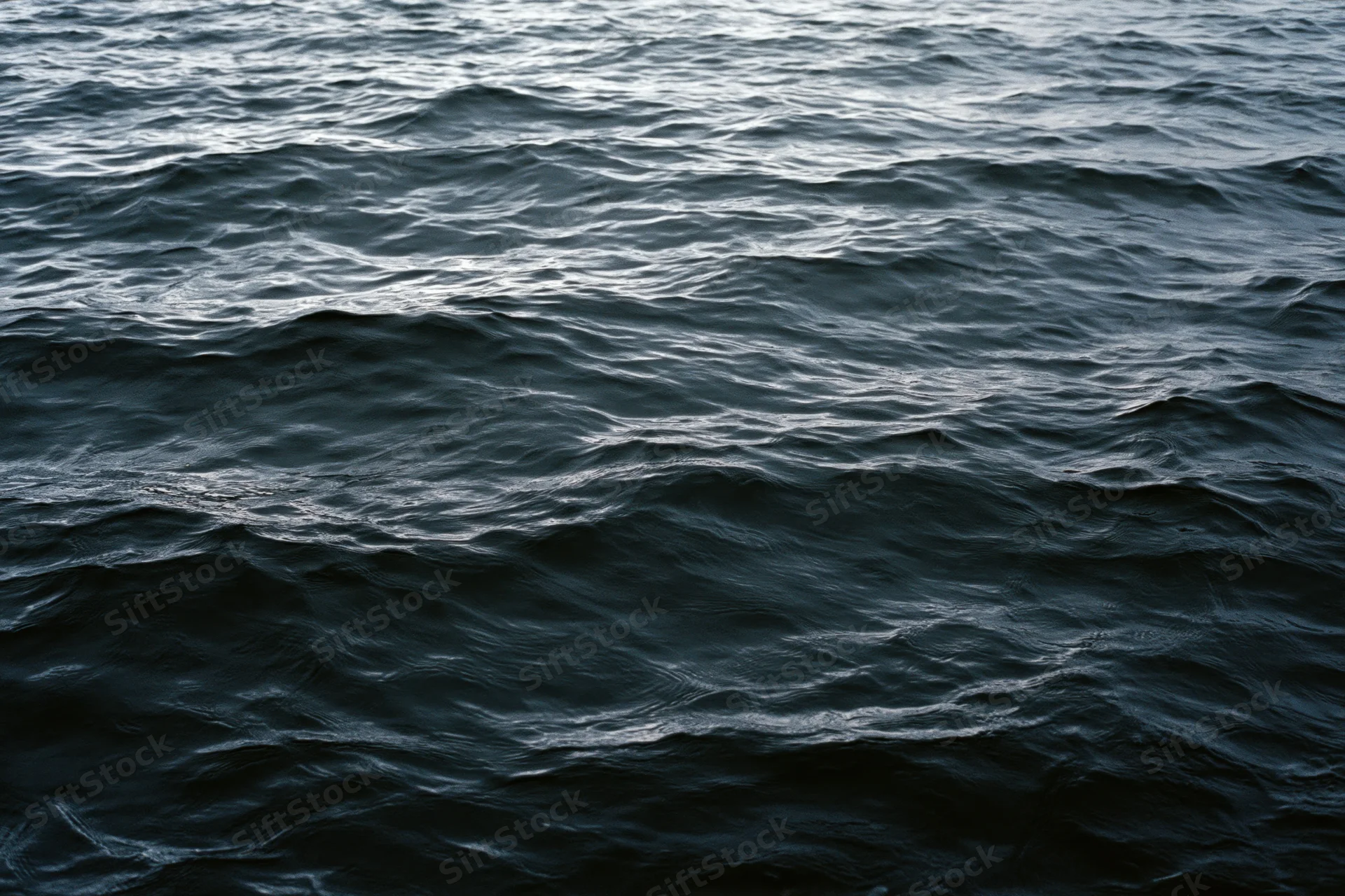 Dark rippling ocean surface viewed from above filling the frame