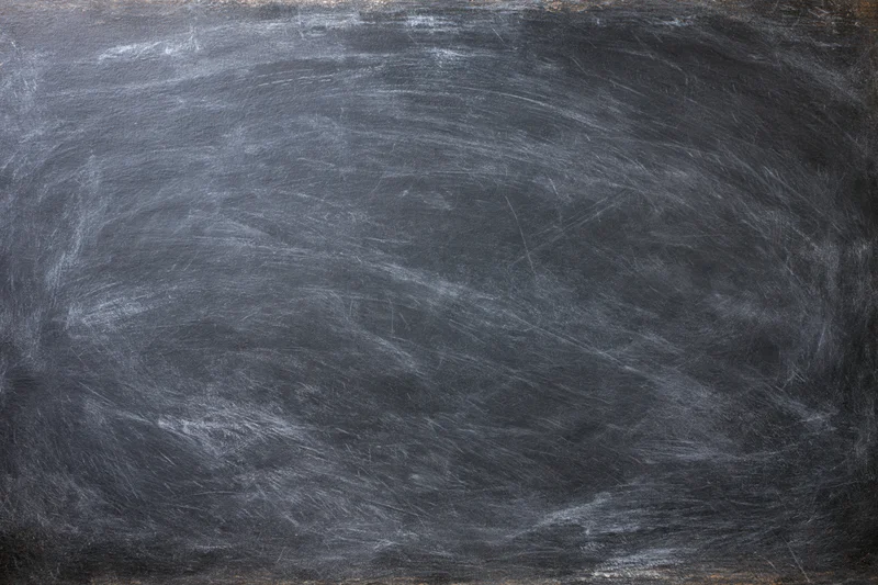 Dark slate chalkboard surface with faint erased chalk marks and smudges