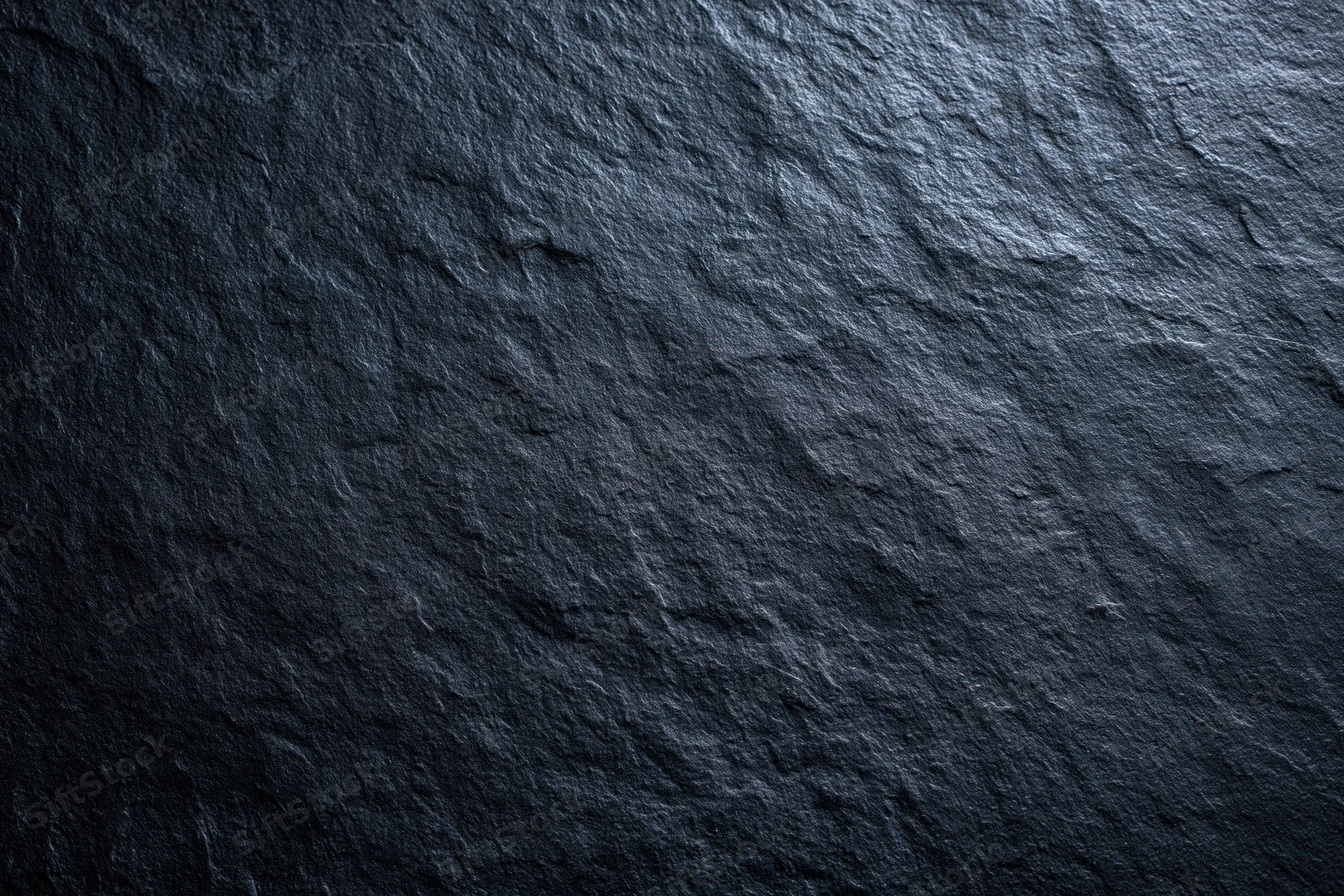 Close-up of dark slate stone surface texture filling the frame