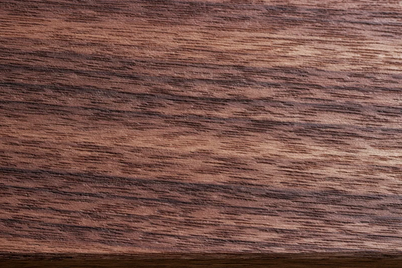 Dark walnut wood surface with visible grain pattern filling the frame