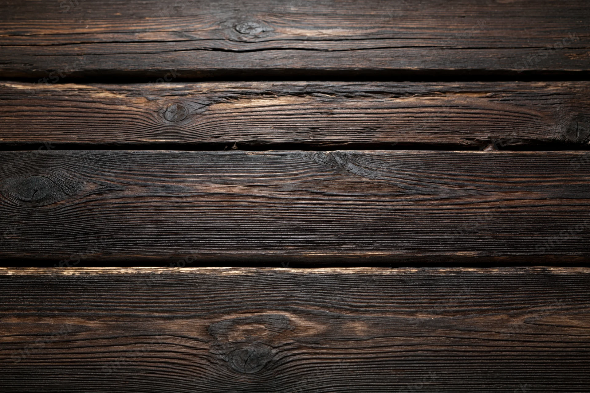 Dark weathered wooden planks arranged horizontally filling the frame