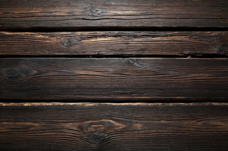 Dark weathered wooden planks arranged horizontally filling the frame