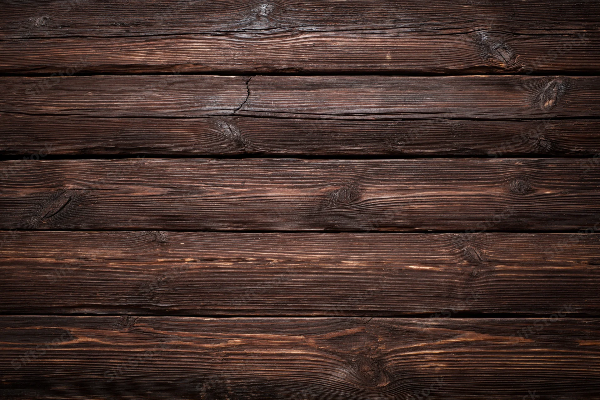 Dark weathered wooden planks arranged horizontally filling the frame