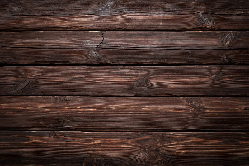 Dark weathered wooden planks arranged horizontally filling the frame
