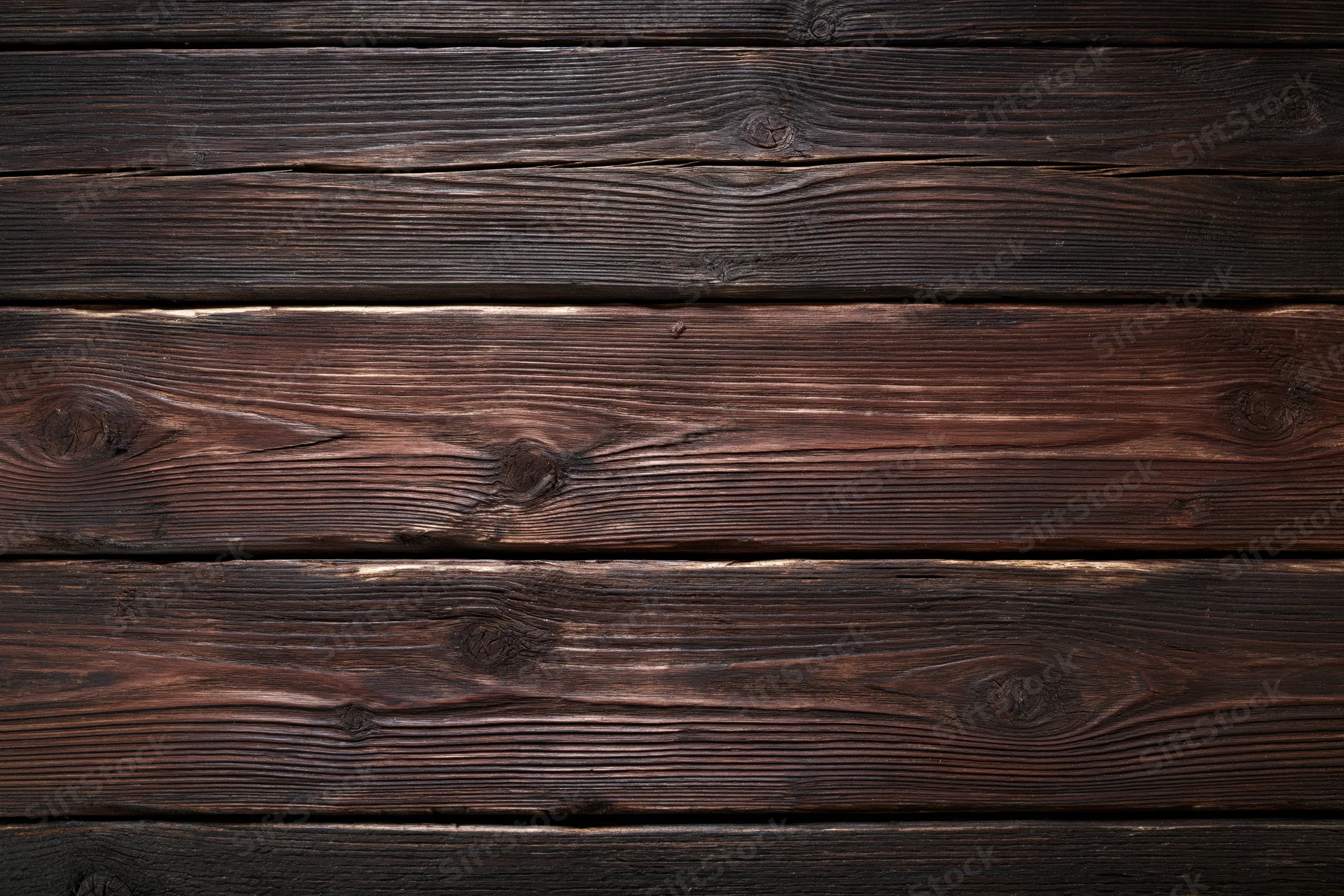 Dark weathered wooden planks arranged horizontally filling the frame