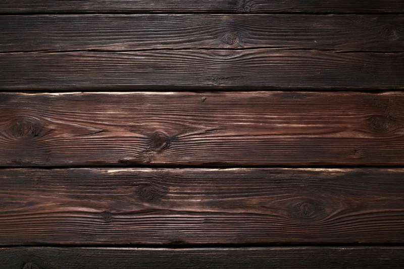 Dark weathered wooden planks arranged horizontally filling the frame