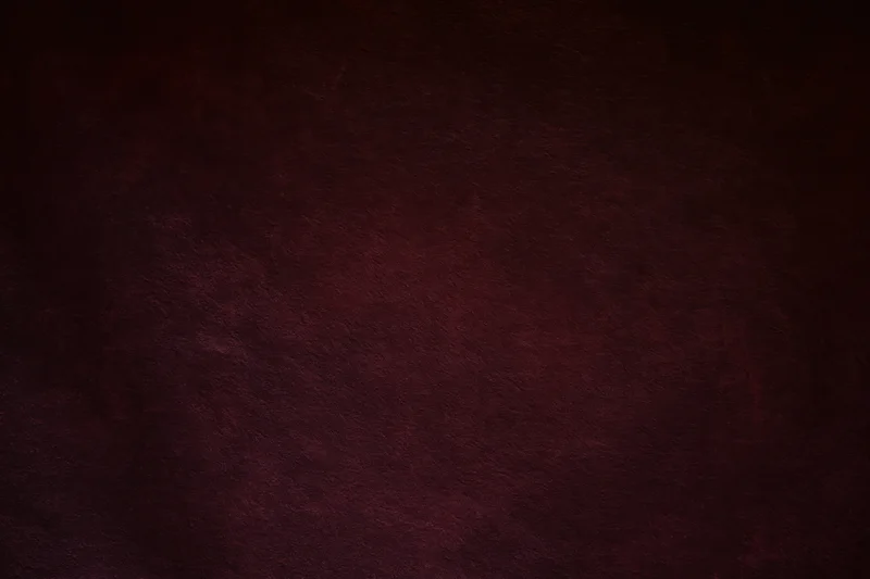 Deep dark maroon textured background with subtle gradient and warm tone
