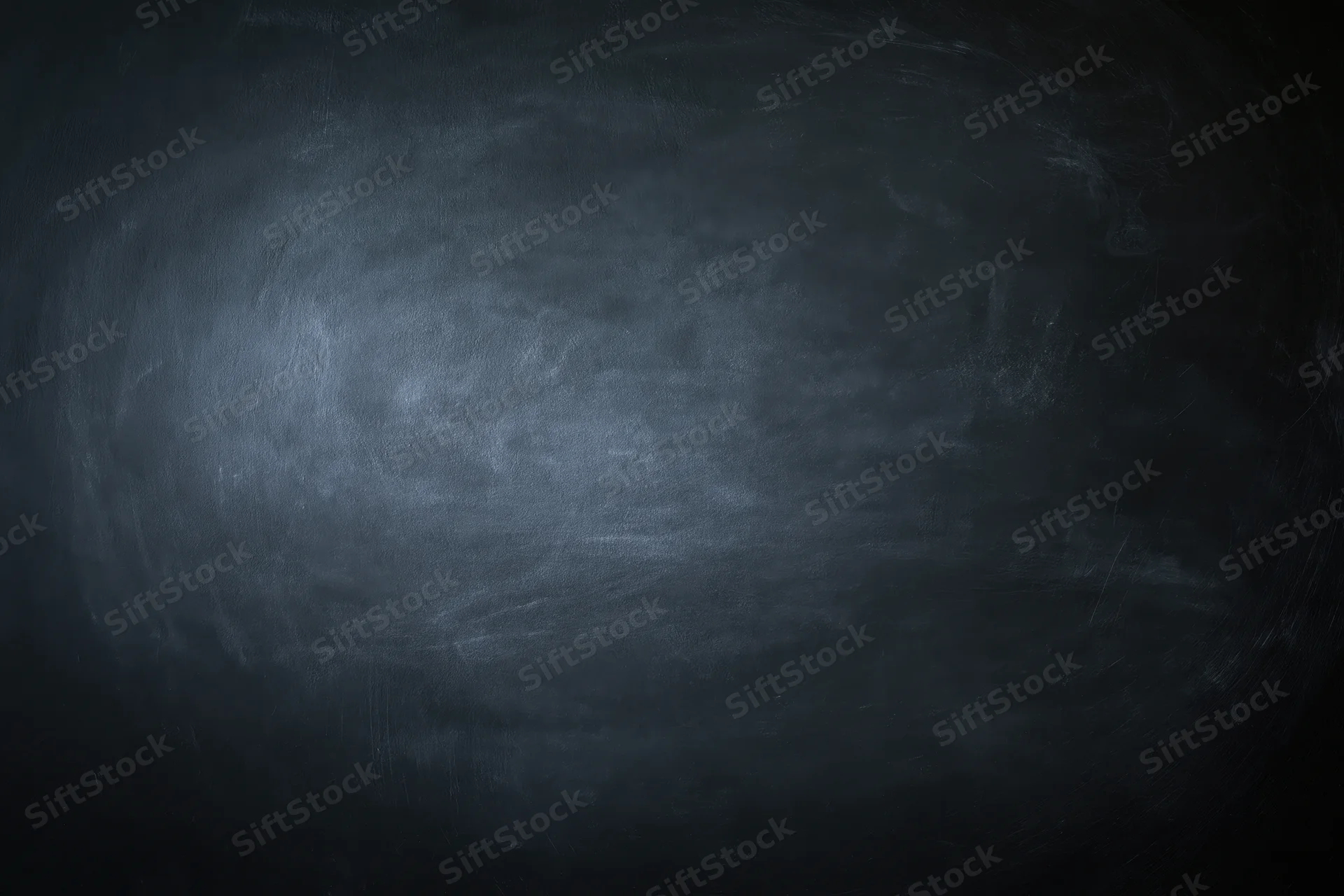Close-up of an empty blackboard surface with smudged chalk residue and dark gray texture filling the frame
