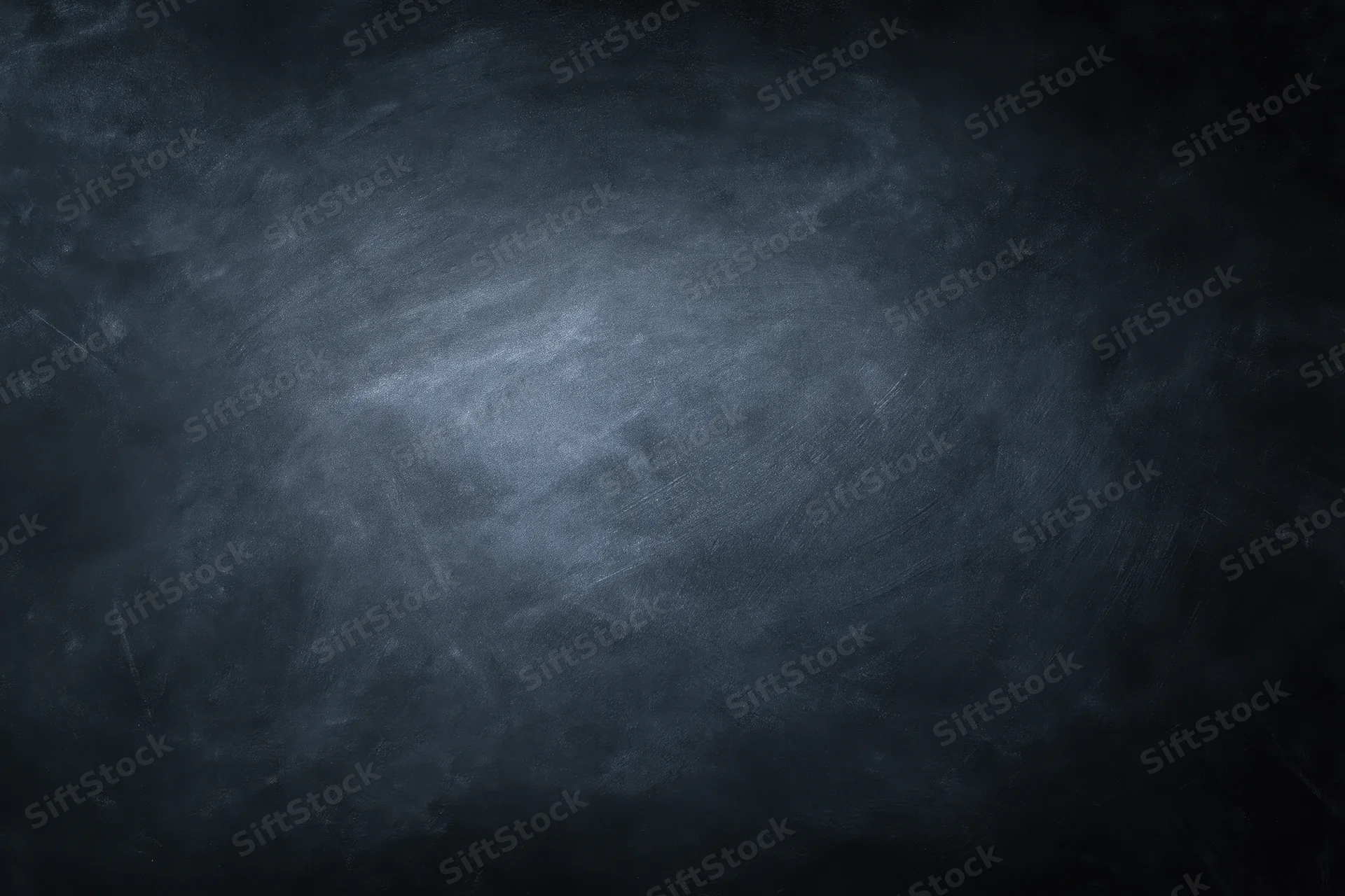 Close-up of an empty blackboard surface with smudged chalk marks and dark gray texture filling the frame
