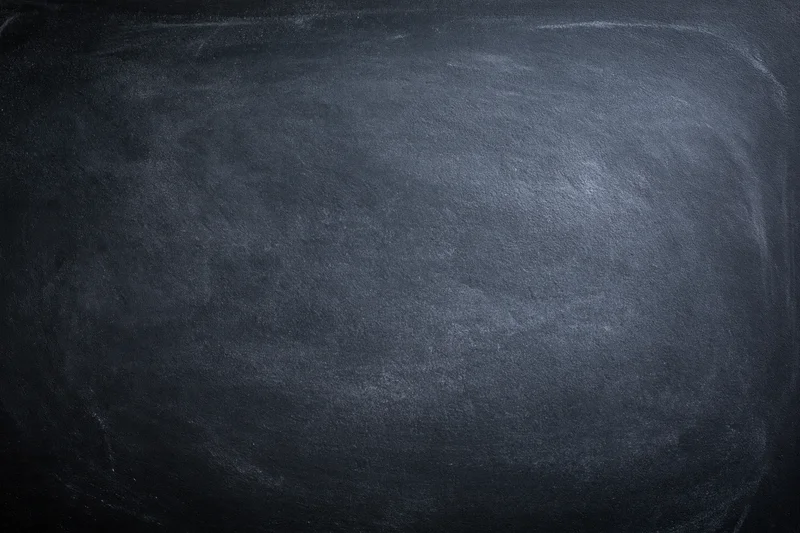Close-up of an empty blackboard surface with smudged chalk marks filling the frame