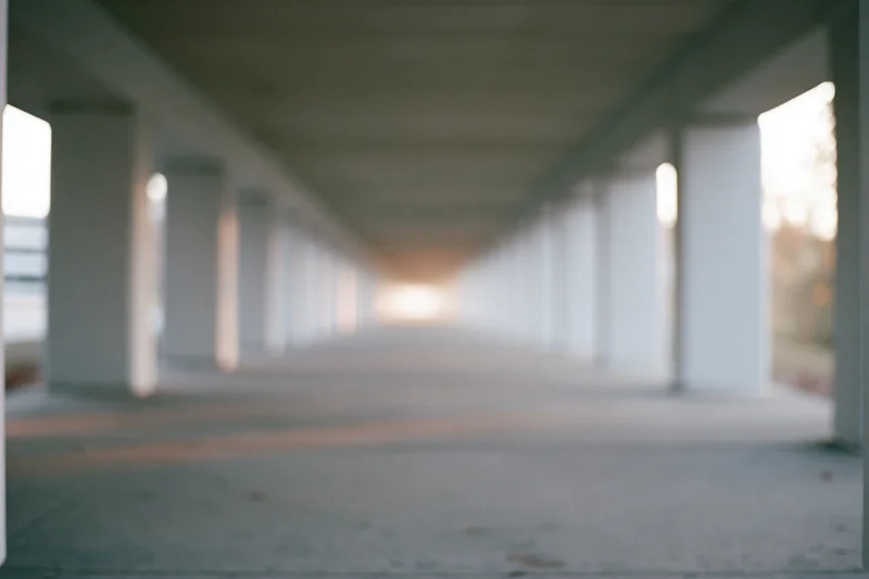 Concrete underpass corridor receding into soft light at dusk