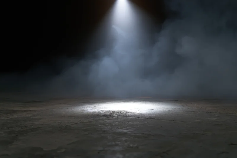 Spotlight beam illuminating smoke over dark concrete floor