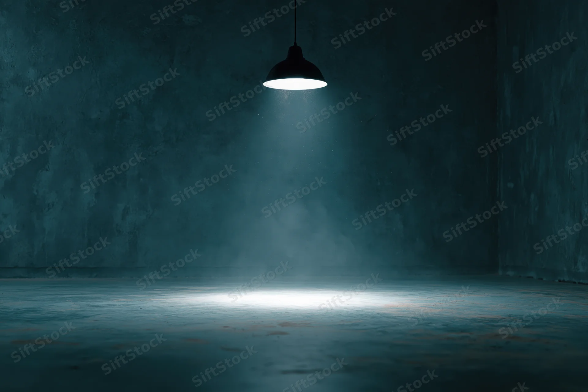 Single pendant spotlight casting a beam of light on a concrete floor in a dark empty room