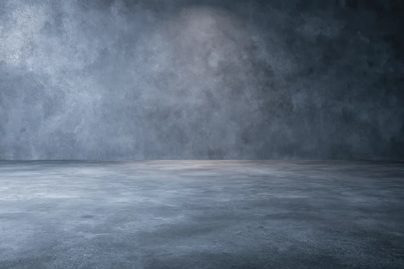 Empty dark grey concrete studio with smooth floor and textured walls