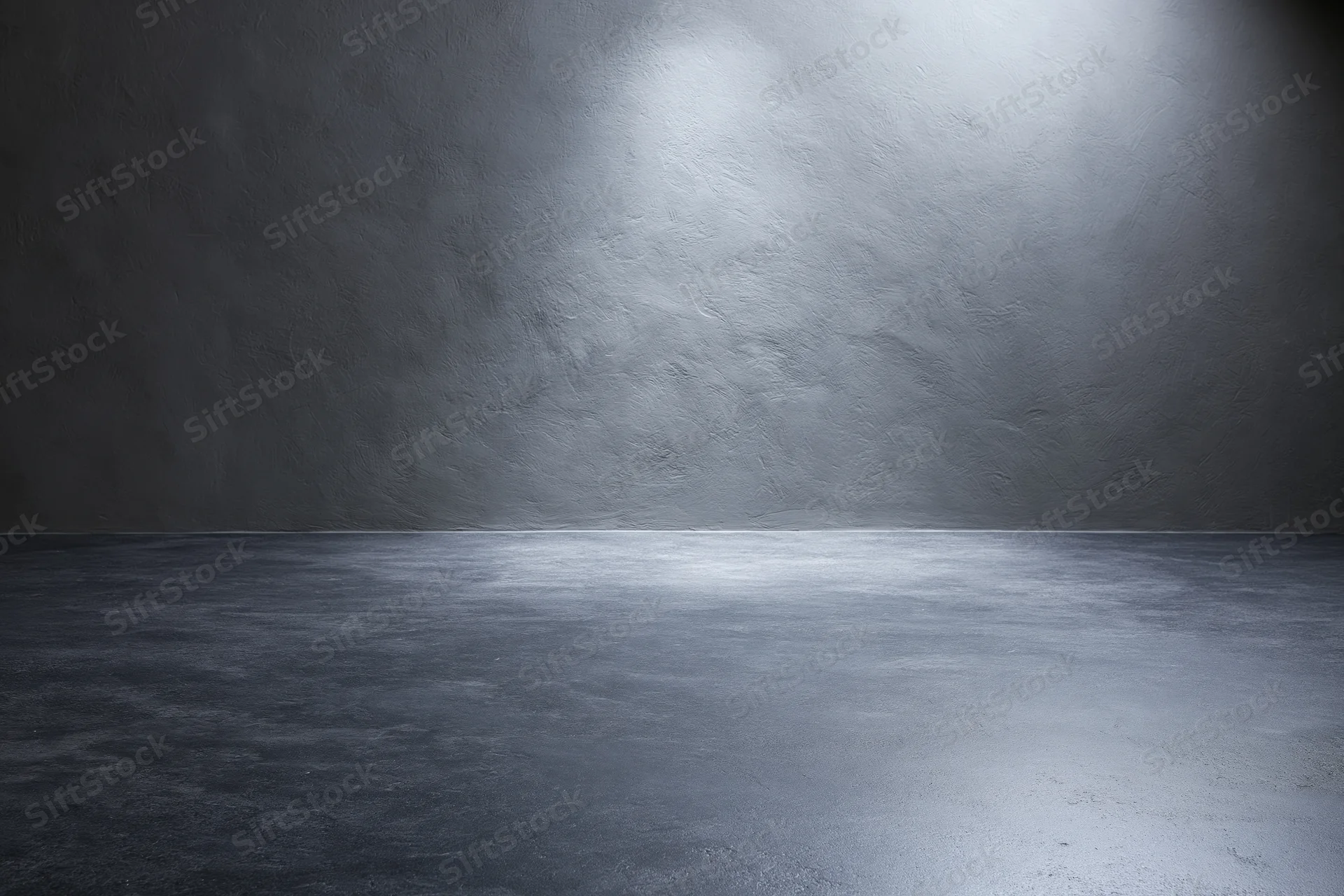 Empty dark grey concrete studio with smooth floor and spotlighted wall