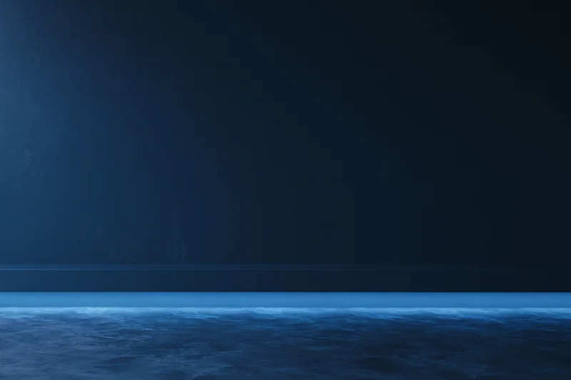 Dark navy blue studio backdrop with flat matte wall and horizontal line across the frame