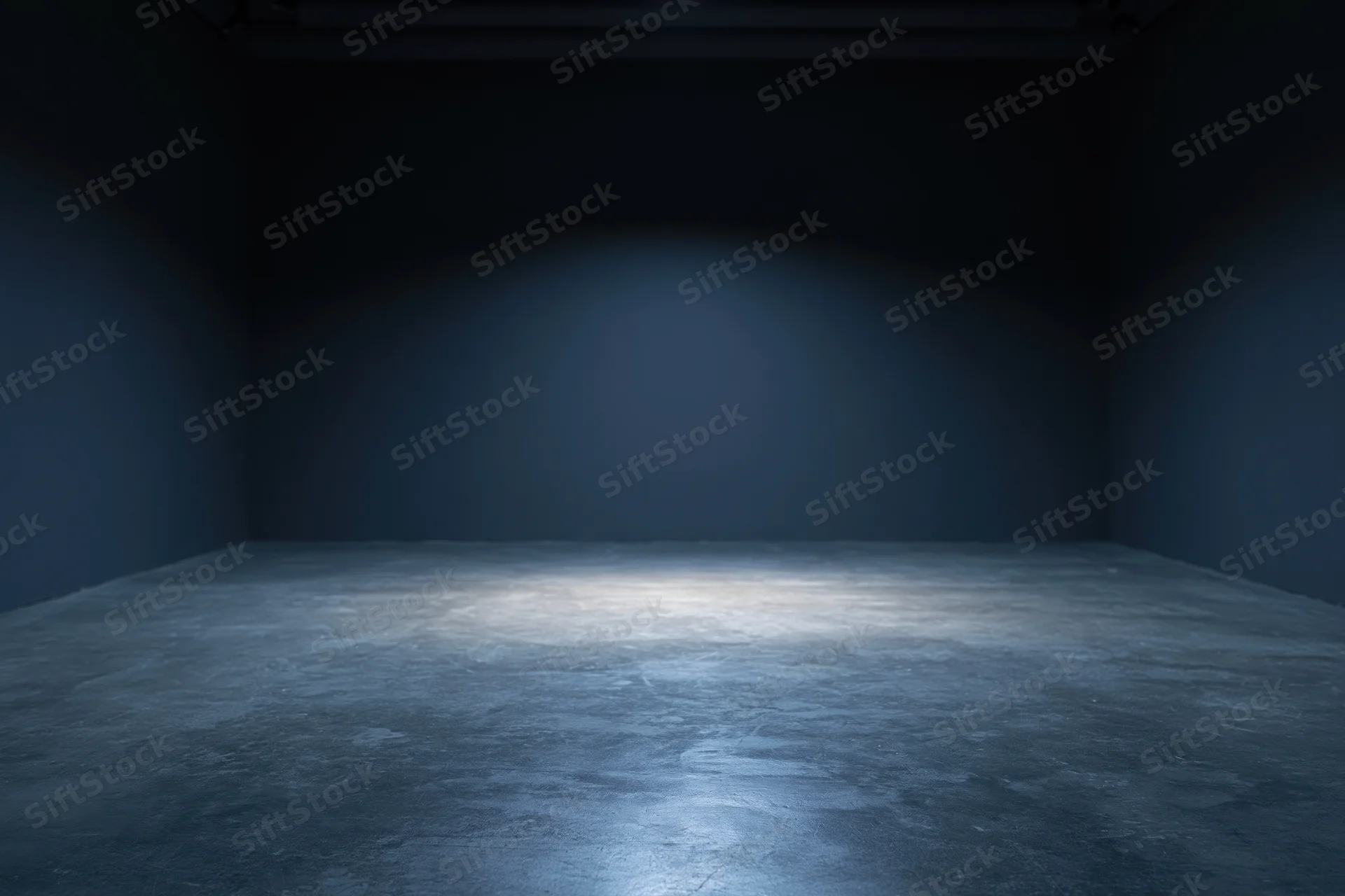 Dark empty studio room with spotlight on concrete floor and plain walls