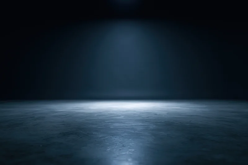 Spotlight on a dark concrete floor in an empty studio space