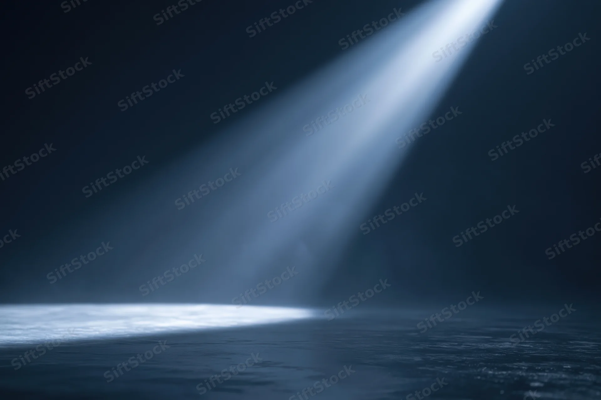 Diagonal spotlight beam illuminating dark studio floor
