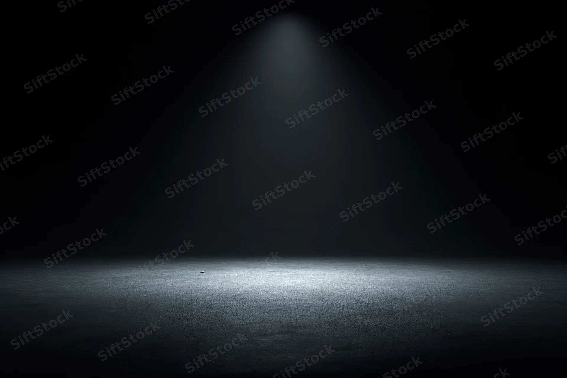Single spotlight illuminating a dark studio floor, centering on an empty space for display