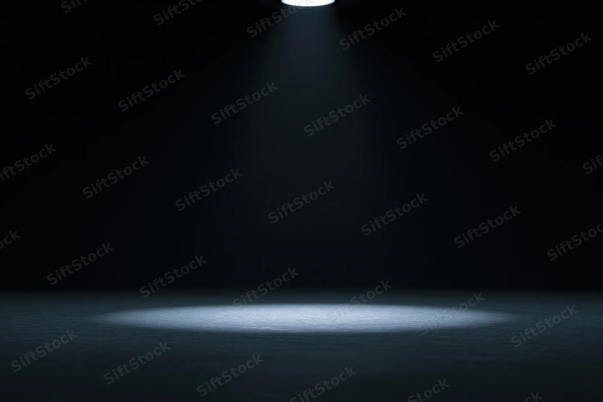 Single overhead spotlight illuminating a dark studio floor with a focused beam of light