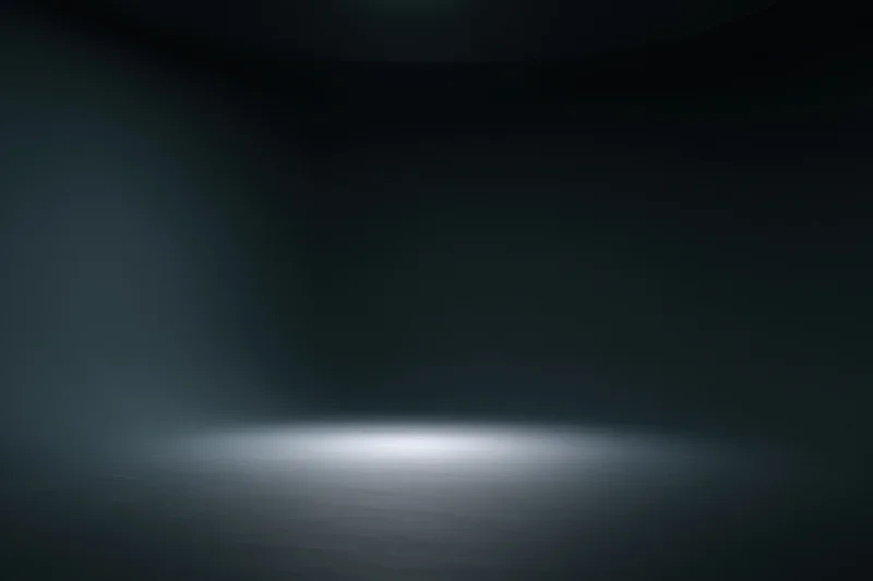 Dark empty studio space with spotlight on seamless floor surface