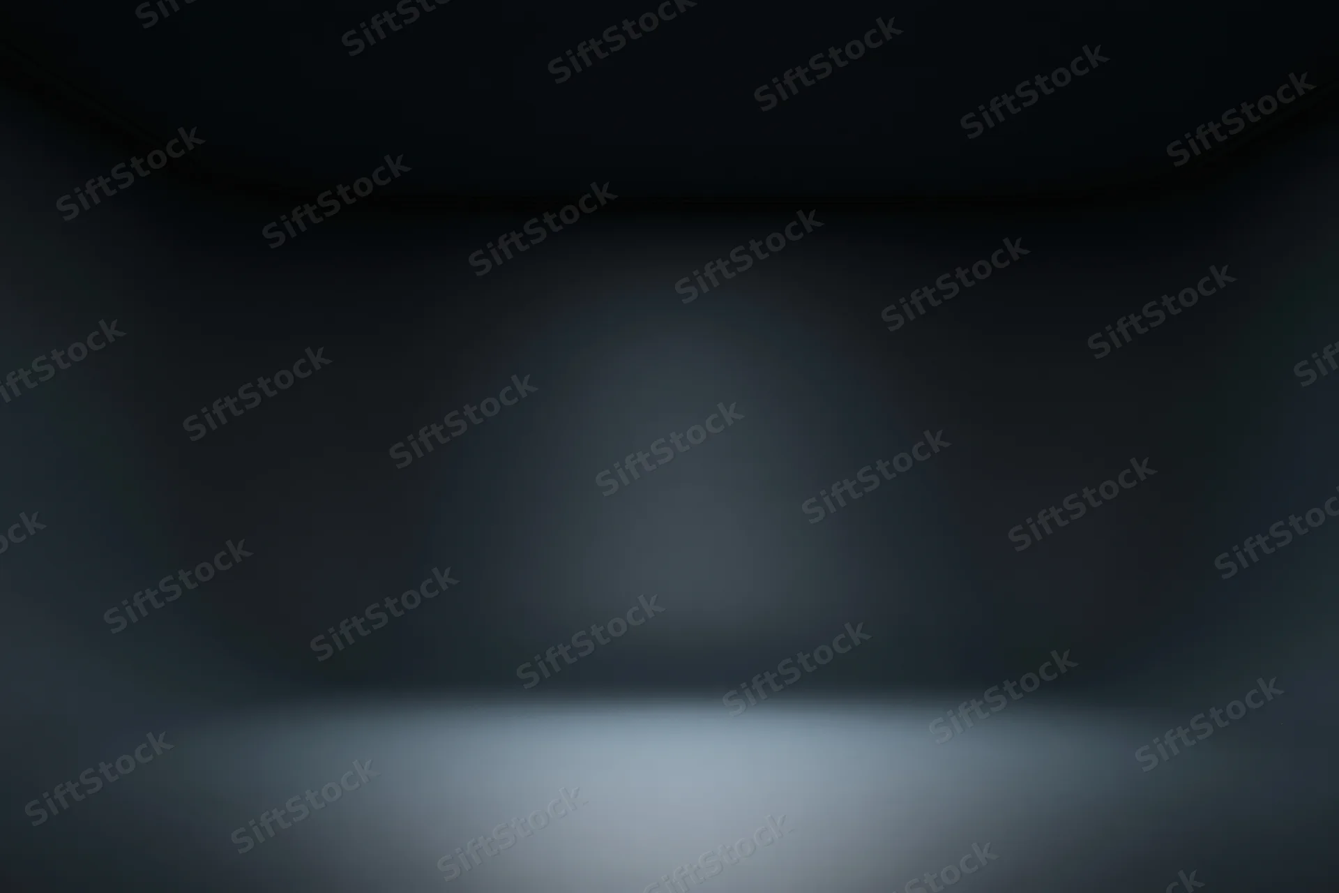 Dark studio interior with seamless curved walls and spotlighted floor, empty space for product display