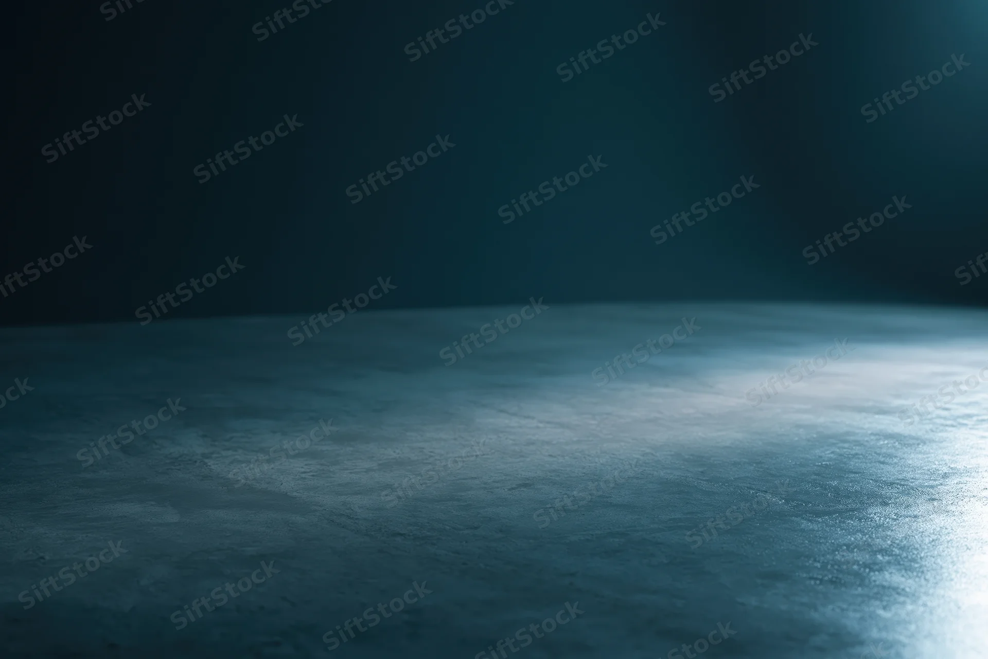 Dark studio floor illuminated by a single horizontal beam of light