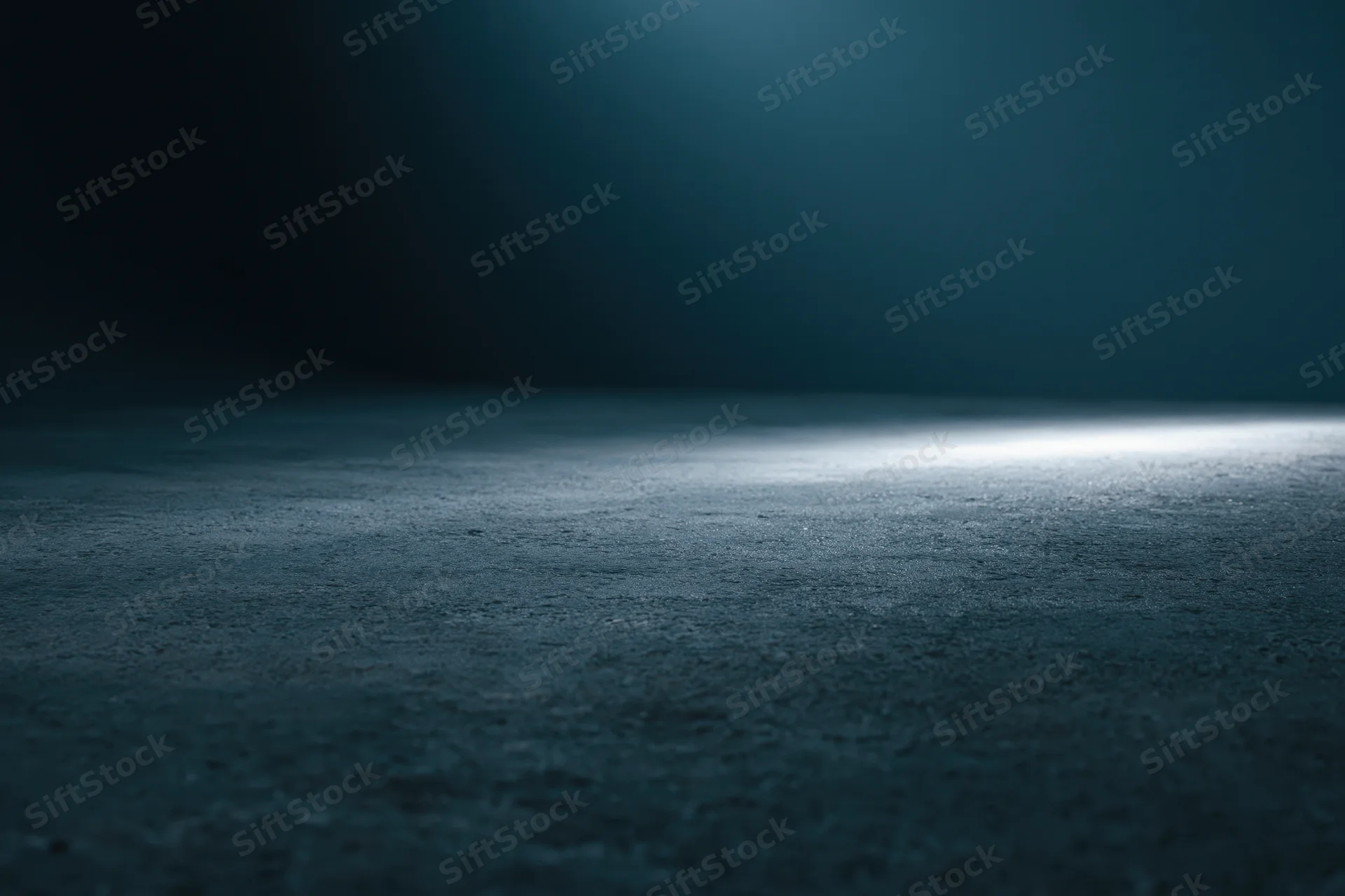 Dark studio floor illuminated by a single horizontal beam of light