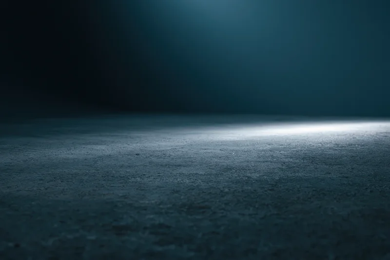 Dark studio floor illuminated by a single horizontal beam of light